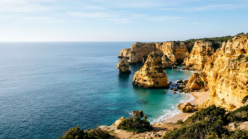 Golden limestone cliffs and sea arches at Praia da Marinha beside calm blue sea.